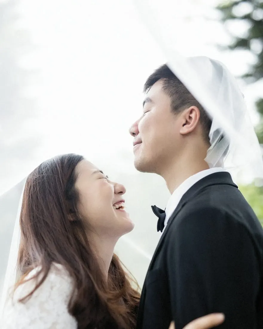 คู่บ่าวสาวยิ้มให้กันใต้ผ้าคลุมหน้าเจ้าสาว